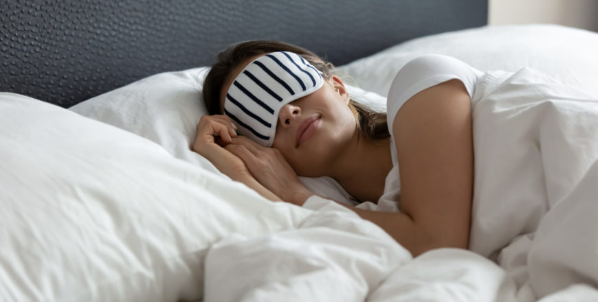Woman in bed with sleep mask