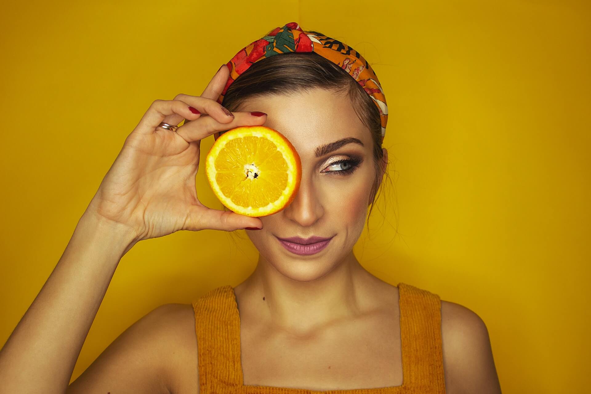 Vitamin C is important for skincare - orange over ladies skin and eye